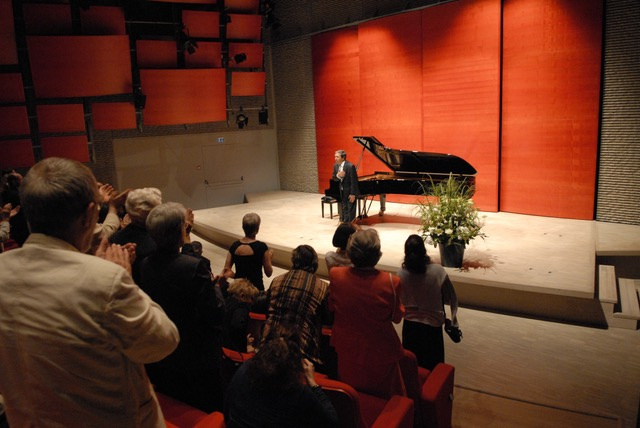Pianist steht vor applaudierendem Publikum