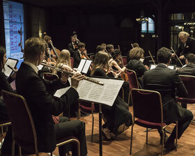 Sicht von hinten auf ein kleines spielendes Orchester
