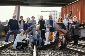 Zwölfköpfige Camerata Variabile mit Streichern und Bläsern auf Geleisen